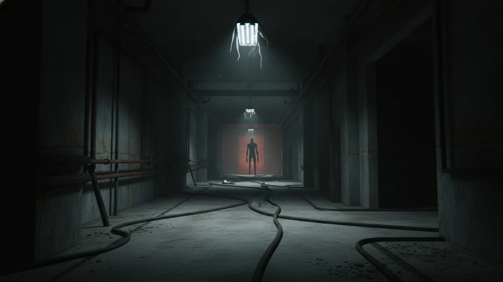 First-person view down a terrifying industrial corridor with a faint silhouette at the end.